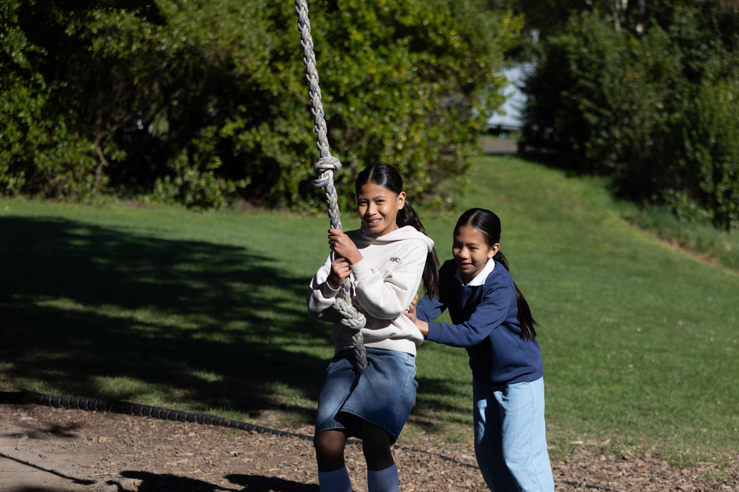 Two children playing on a tree swing at Living Springs