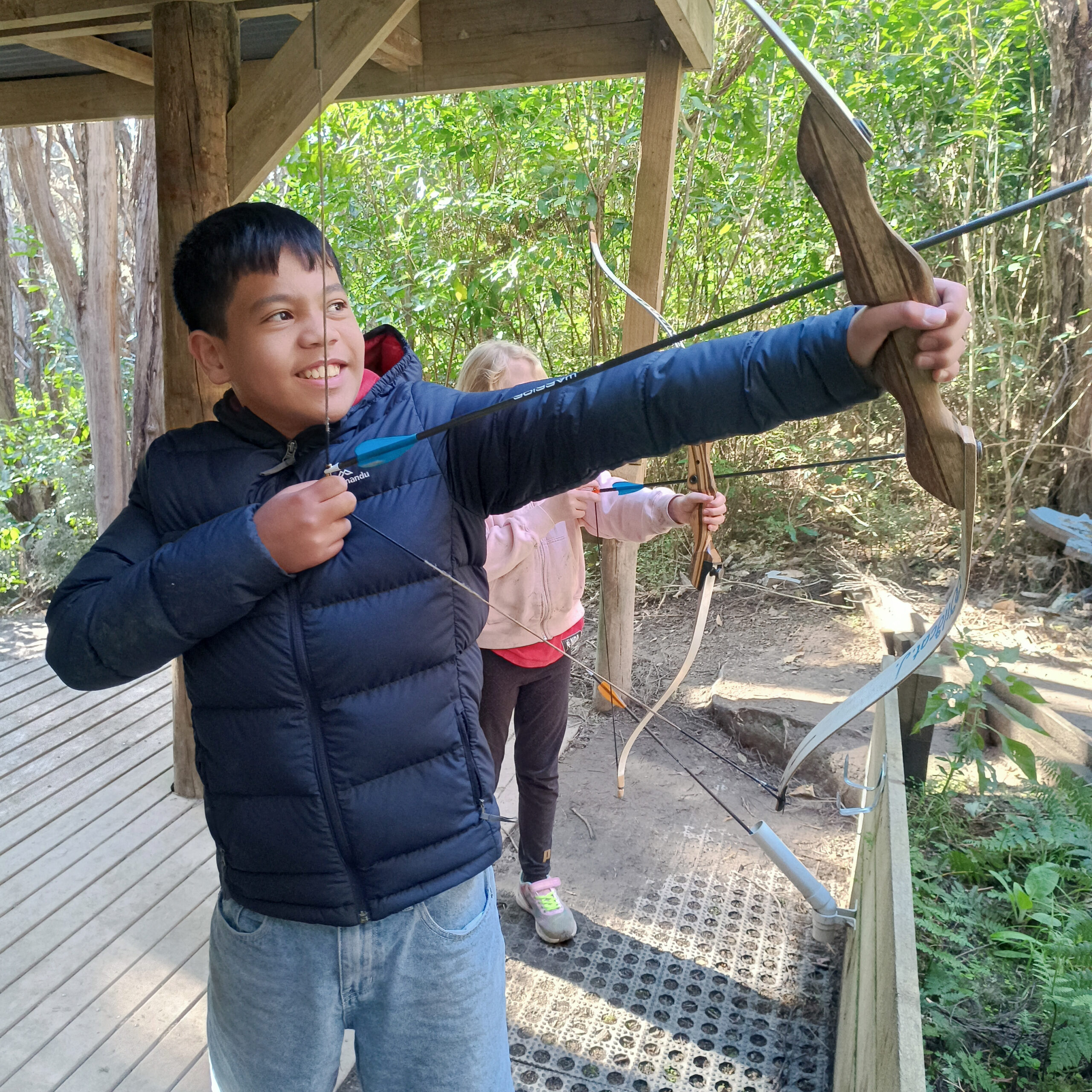 A child practicing archery at Living Springs